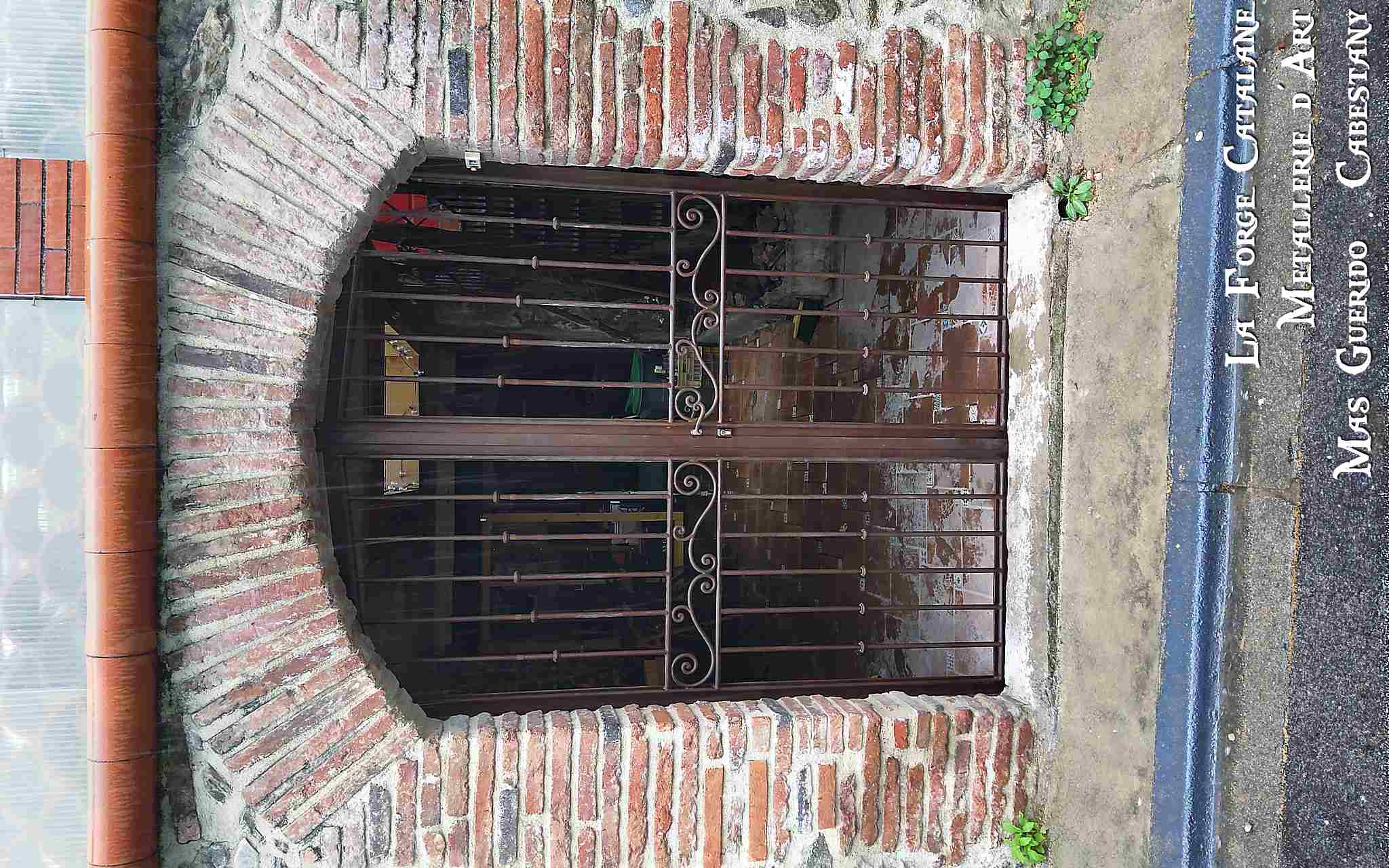 grille de protection deux vantaux frise avec volutes travaillees a chaud  au centre bagues forge catalane.jpg